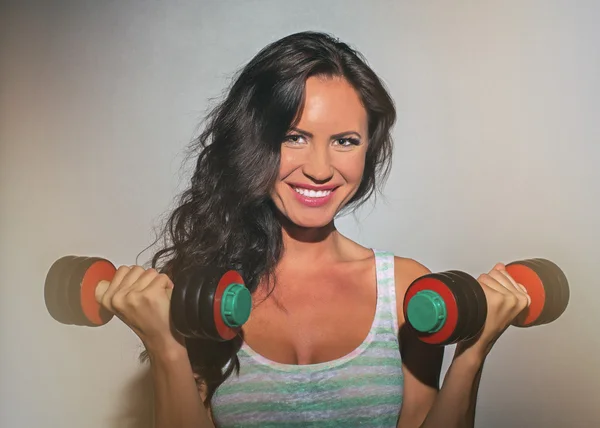 Attractive brunette woman working out with dumbbells. — Stock Photo, Image