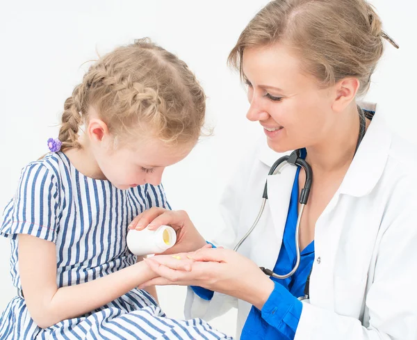 Female doctor giving vitamins to little girl. — Stock Photo, Image