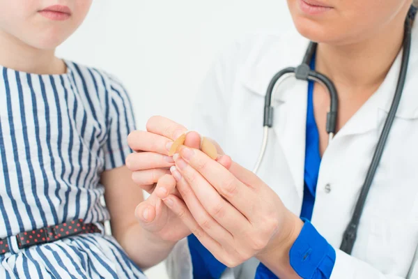 Arzt legt Klebeverband auf Kinderfinger. — Stockfoto