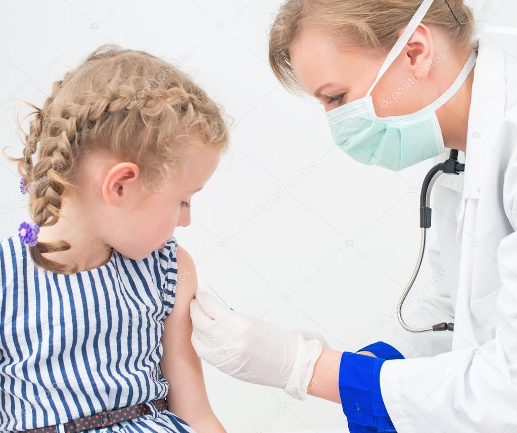 Female doctor doing vaccine to little girl.