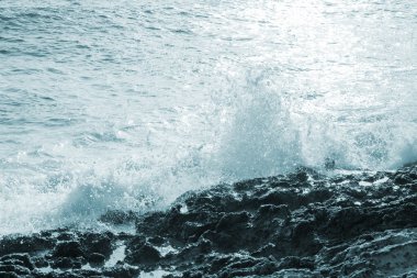 Büyük rüzgarlı dalgalar kayaların üzerine sıçramasına. Fırtına başlıyor.