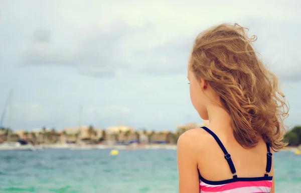 Sad little girl looking at the sea. — Stock Photo, Image