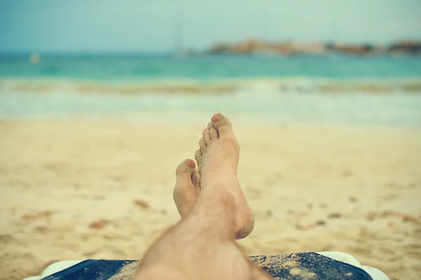 ラウンジャーでの日光浴の男。脚。ヴィンテージ効果. — ストック写真