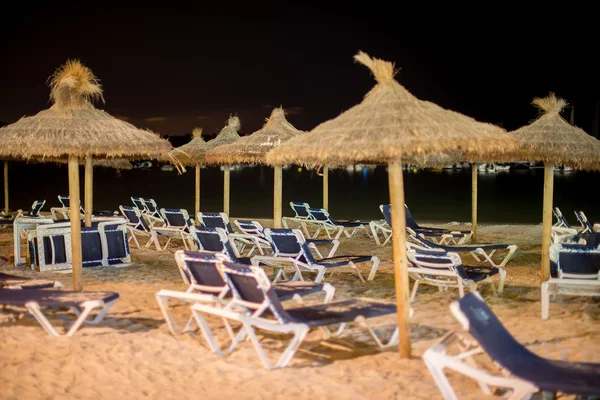 Jede Menge Liegestühle am Strand in der Nacht. — Stockfoto