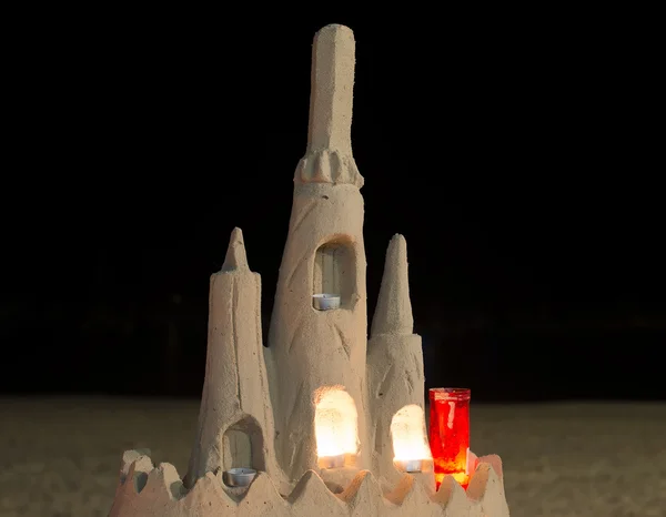 Замок зі свічками з піску на пляжі . — стокове фото