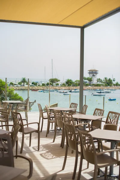 Empty outdoor street cafe by the sea. — Stock Photo, Image