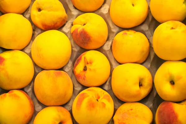 Row of ripe peaches in supermarket. — Stock Photo, Image