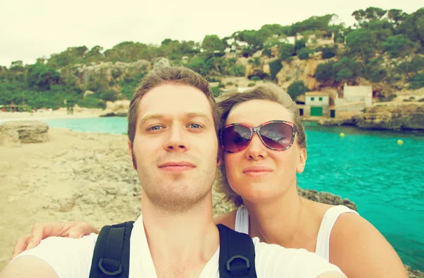 Selfie. Um casal a tirar fotografias na praia. Vintage foto efeito . — Fotografia de Stock