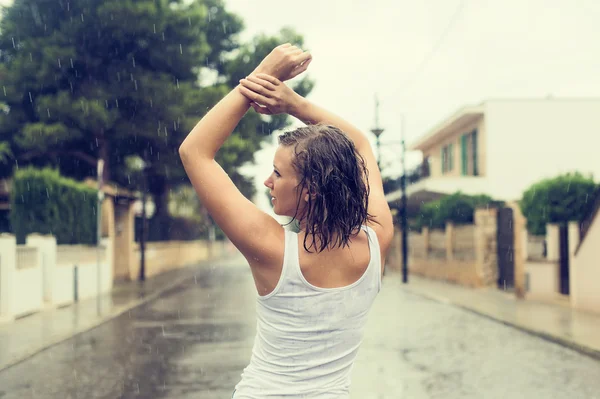 Ευτυχισμένος ξανθιά γυναίκα απολαμβάνοντας τροπική βροχή. Vintage αποτέλεσμα φωτογραφία. — Φωτογραφία Αρχείου