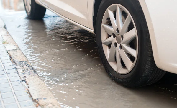 Coche durante las fuertes lluvias en la ciudad . —  Fotos de Stock