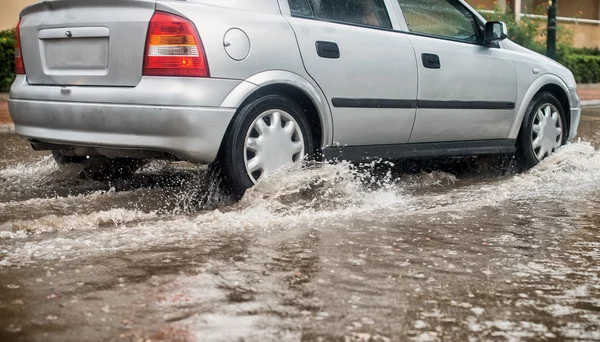 Coche durante las fuertes lluvias en la ciudad . — Foto de Stock