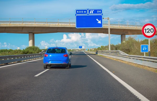 Asfalterad väg med bron och blå bil. — Stockfoto