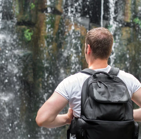 Tourist mit Rucksack in der Nähe des Wasserfalls. Raum für Ihren Text. — Stockfoto