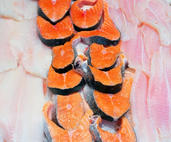 Trozos rebanados de diferentes pescados en el mercado . — Foto de Stock