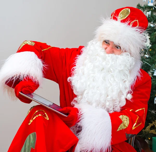 Angry Santa Claus breaks tablet pc. — Stock Photo, Image