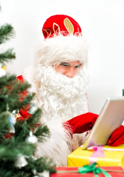 Santa Claus está utilizando la tableta PC en su taller . — Foto de Stock