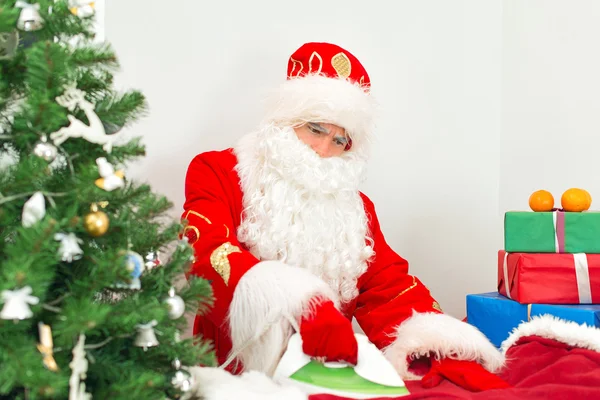 Santa Claus žehlení oblečení před svátky. — Stock fotografie