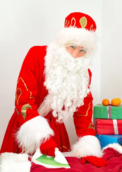 Santa Claus plancha ropa antes de las vacaciones . — Foto de Stock