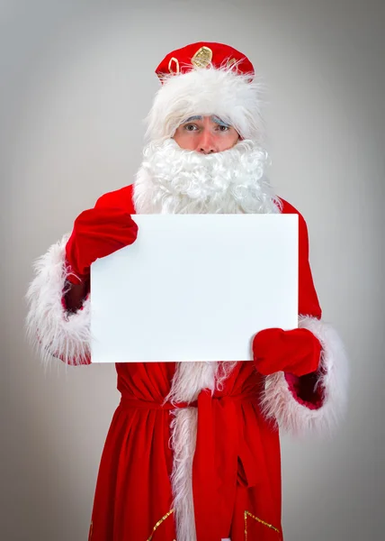 Patético Santa Claus está sosteniendo blanco en blanco . — Foto de Stock