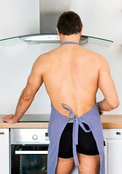 Mężczyzna przygotowywania potraw w kuchni. Widok z tyłu. — Zdjęcie stockowe