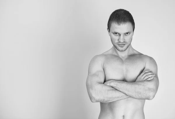 Muskulöses männliches Modell mit verschränkten Armen. Schwarz-Weiß. Platz für Text. — Stockfoto
