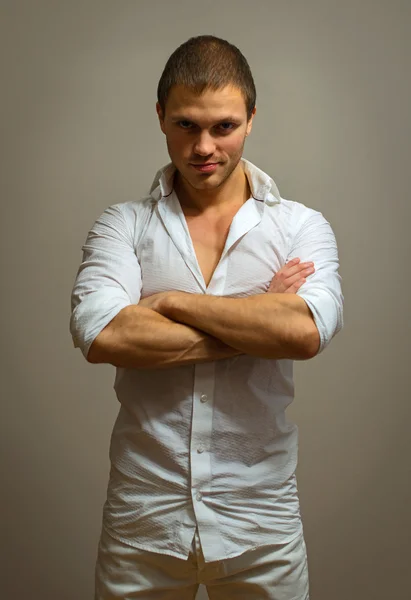 Modelo masculino atraente posando em fundo cinza . — Fotografia de Stock