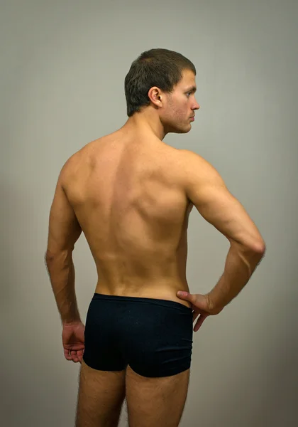 Modelo masculino muscular posando. Visão traseira . — Fotografia de Stock