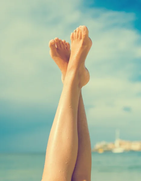 Närbild av kvinnors ben på stranden. — Stockfoto