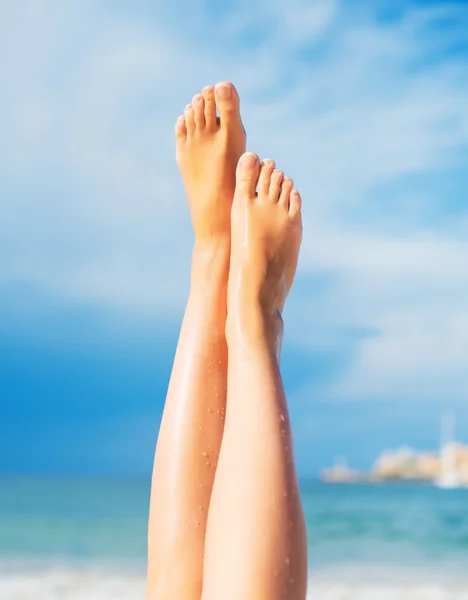 Close-up zicht op vrouwenbenen op het strand. — Stockfoto