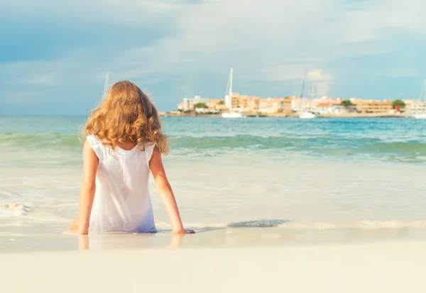 Little girl sunbathing near the sea. — Stock Photo, Image