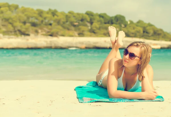 Jovem mulher tomando banho de sol na praia tropical . — Fotografia de Stock
