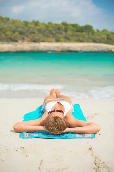 Młoda kobieta opalając się na tropikalnej plaży. — Zdjęcie stockowe
