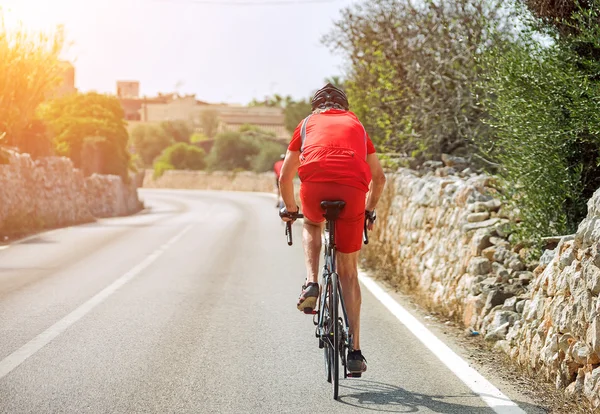 Ciclista masculino montando uma bicicleta na estrada . — Fotografia de Stock