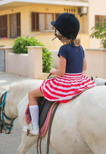 Portrait of little girl riding pony. From the back. — Stock Photo, Image