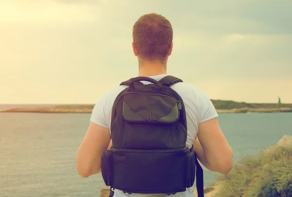 Manliga turist med ryggsäck tittar på havet. — Stockfoto