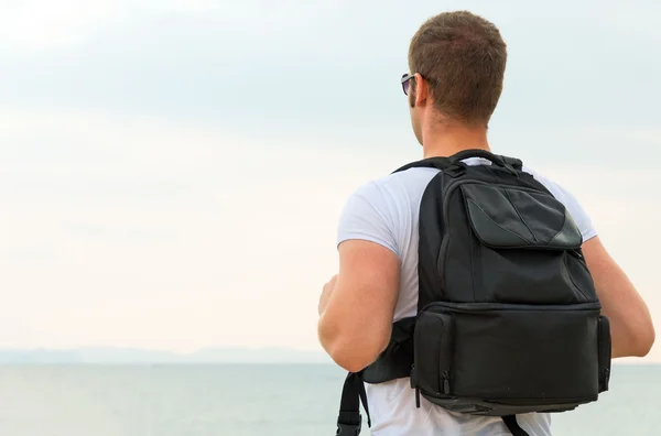 Чоловік турист з рюкзаком дивиться на океан . — стокове фото