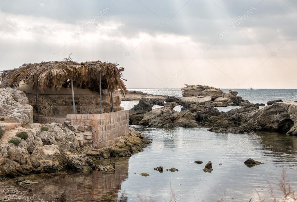 Old fisherman's house on the beach at sunset.