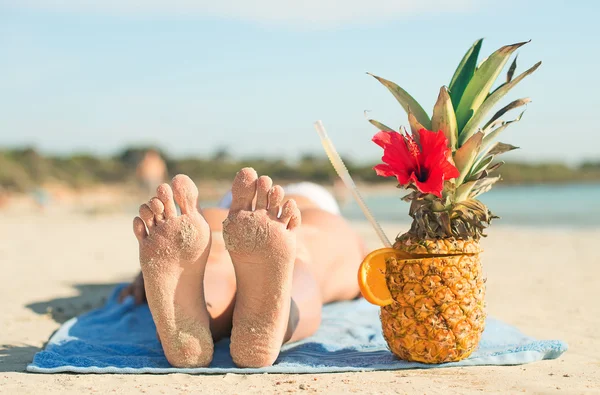 Kobieta z koktajl opalając się na plaży wakacje. — Zdjęcie stockowe