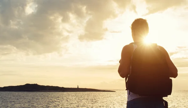 Femme avec sac à dos sur le coucher du soleil . — Photo