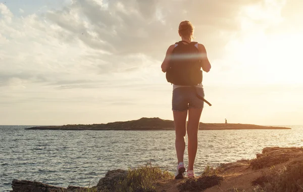 Vrouw met rugzak op de zonsondergang. — Stockfoto