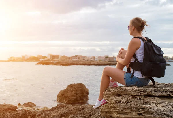 Woman with backpack relaxing near the sea. — Stock Photo, Image