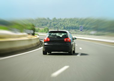 Black car hurtling down the highway. clipart