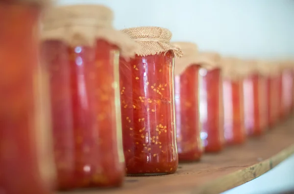 Tomatenkonserven in Glasgefäßen im Holzregal. — Stockfoto