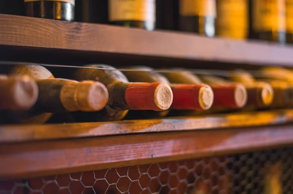 Garrafas de vinho empilhadas em prateleiras de madeira . — Fotografia de Stock