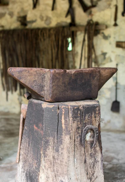 Oude aambeeld op de houten stomp. — Stockfoto