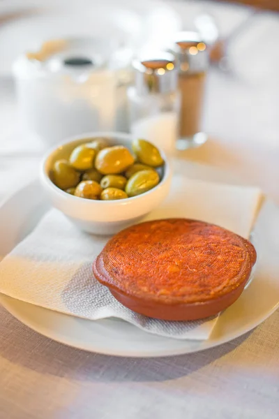 Sobrassada mit Oliven auf einem Tisch im Restaurant. — Stockfoto