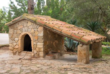 Siyah köpek taş onun köpek kulübesi dinlenme.