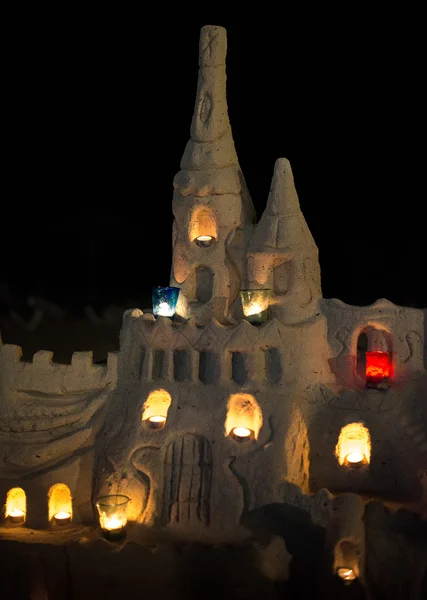 Замок зі свічками з піску на пляжі . — стокове фото
