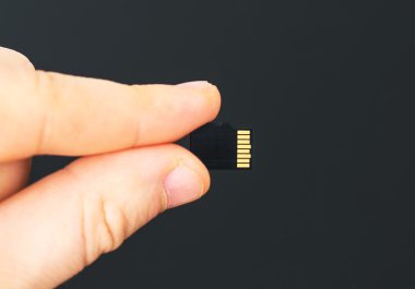 Micro Sd Kart siyah arka planda tutan erkek el.