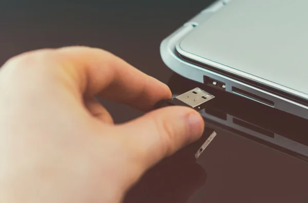 Mano conectar la unidad flash USB a la computadora portátil . — Foto de Stock